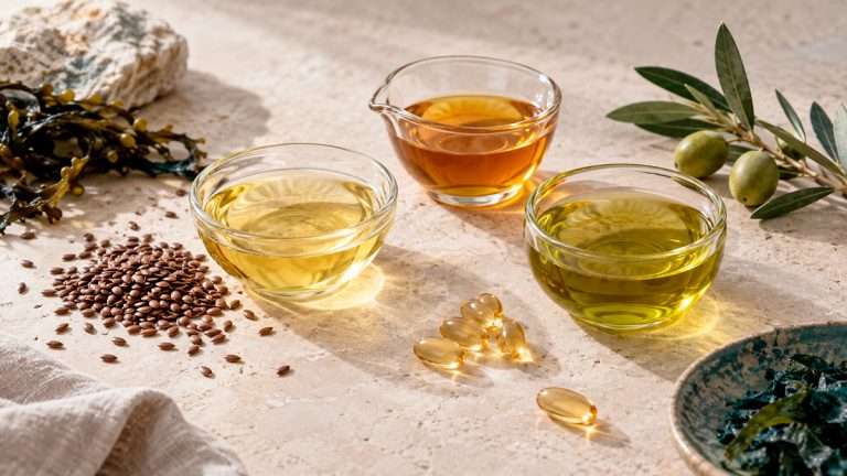 Tres recipientes con aceites y cápsulas de distintas fuentes, representando una fórmula omega 3-6-9